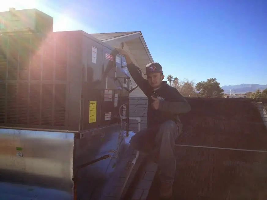 HVAC technician performing Heat Pump Repair on a rooftop unit in Gautier